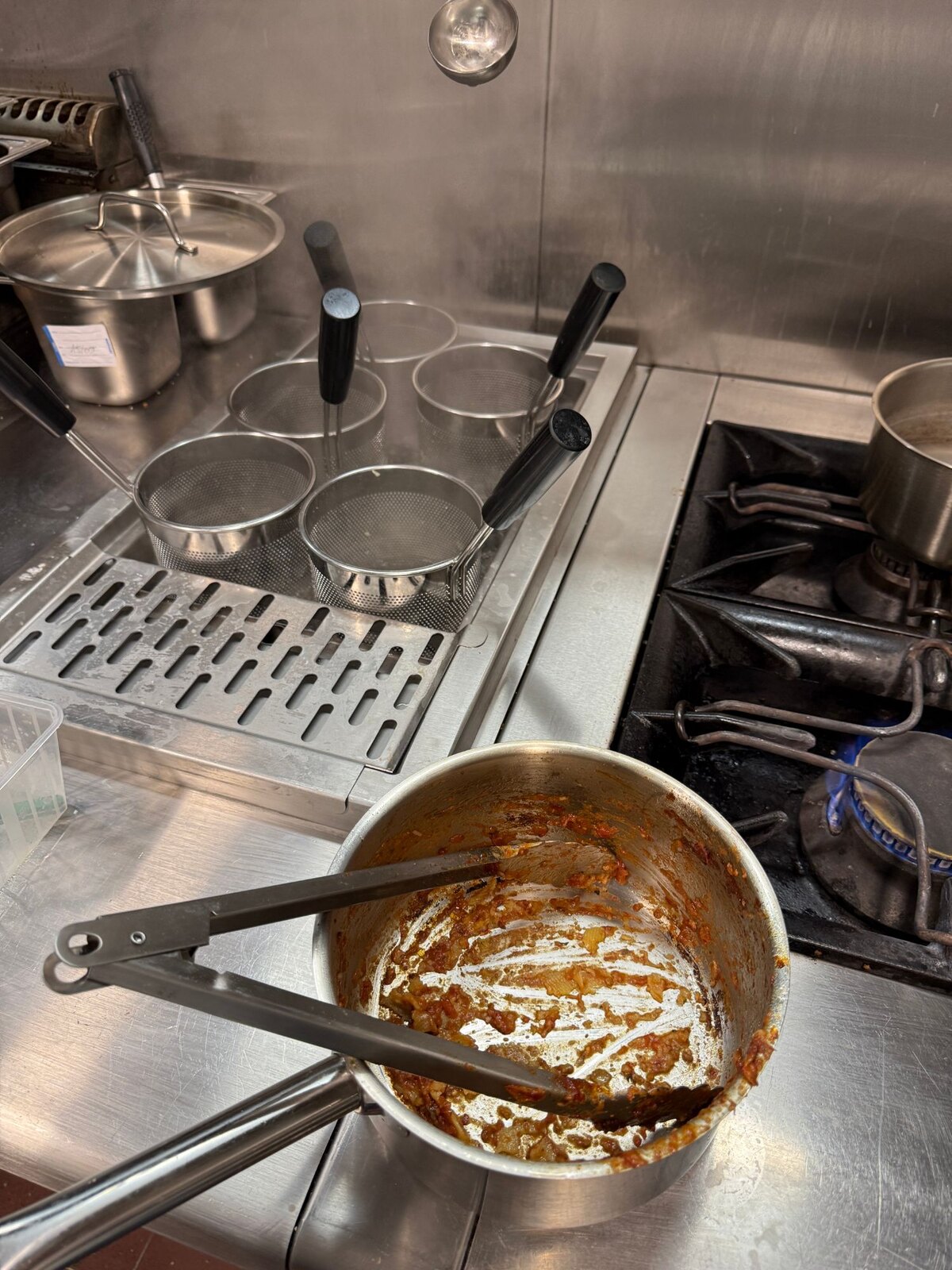 Le piano de cuisson de Monica : casserole de sauce tomate et passoires à pâtes