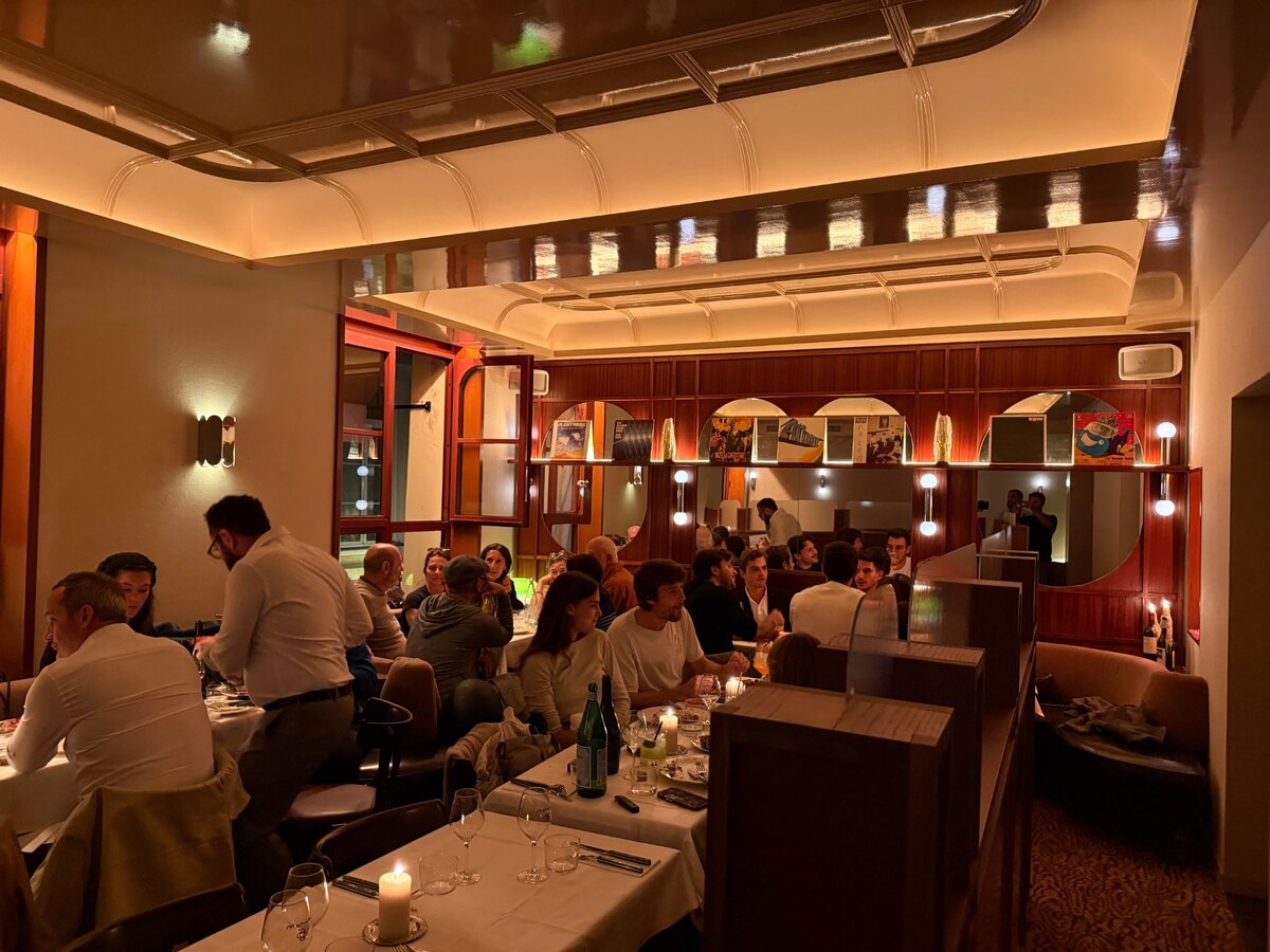 La salle de Monica un soir de service, tables dressées, miroirs et pochettes de disques au mur, Paris 6e